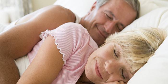 Couple marié souriant dans leur sommeil