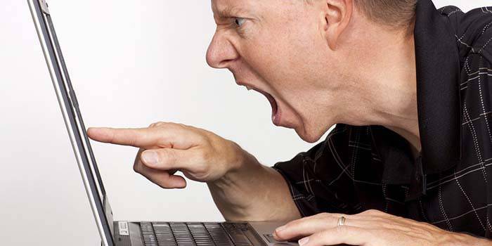 Người đàn ông giận dữ ở máy tính xách tay