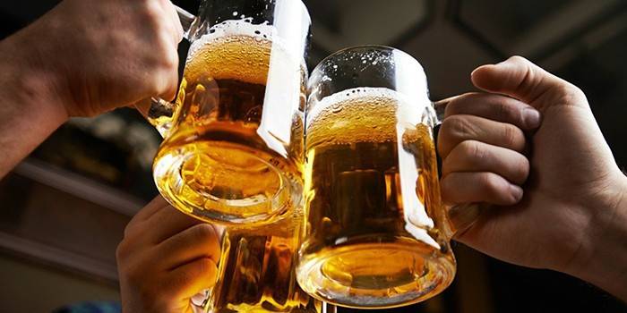 Three men clink glasses with beer