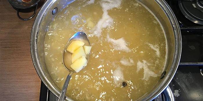 สต็อกไก่ในกระทะและมันฝรั่งในช้อน