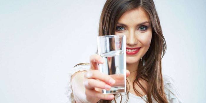 La ragazza dà un bicchiere d'acqua