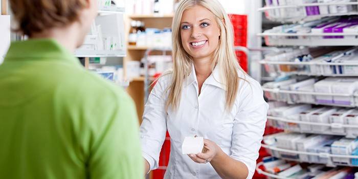Chica farmacéutica aconseja al comprador