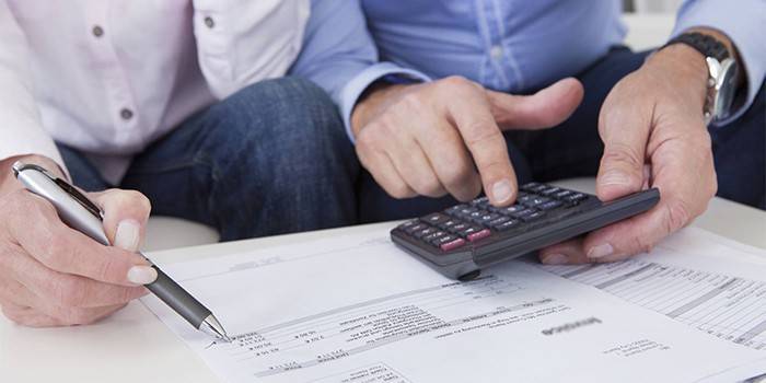 Un bărbat și o femeie calculează pe un calculator