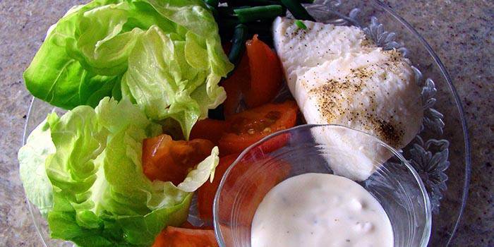 Tavuk göğsü, sebze salatası ve bir tabakta sos