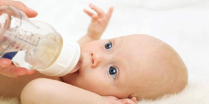 En baby får en flaske vand
