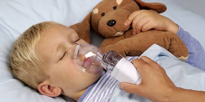 Bambino con un nebulizzatore in faccia.
