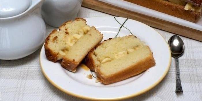Kaksi viipaletta banaanitäytettyä piirakkaa maitotiivisteellä lautaselle