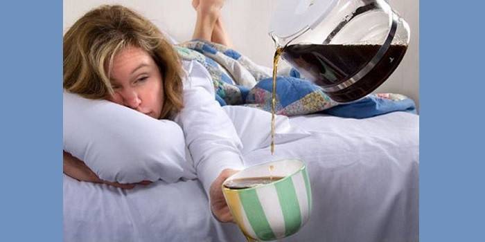Mädchen mit einem Kater gießt Tee in eine Tasse
