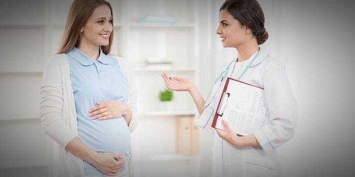 Nėščia moteris kalbasi su gydytoju