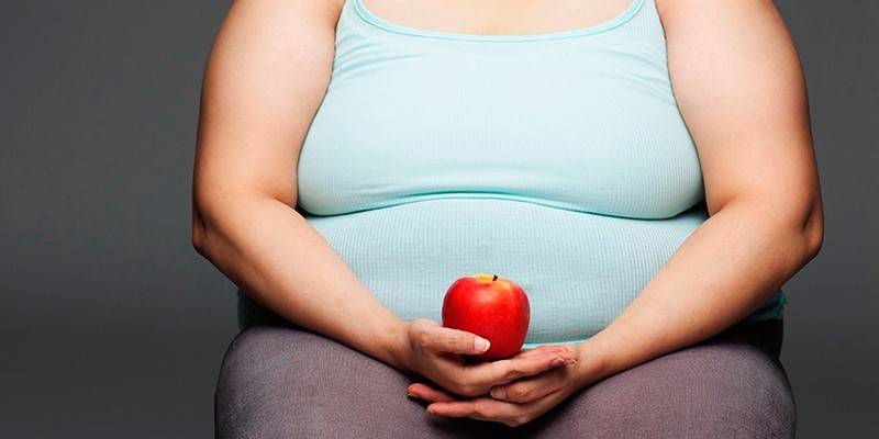 Femme en surpoids avec une pomme dans les mains