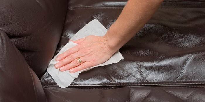 Ang babae ay naghuhugas ng sofa na katad