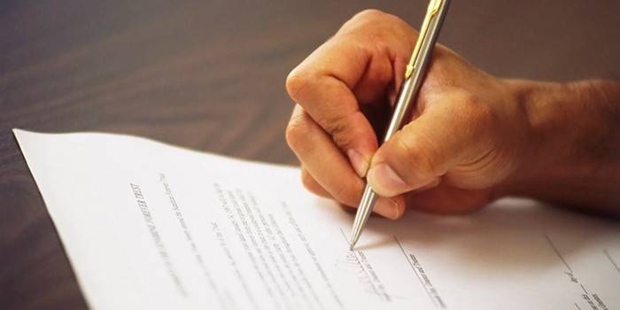 Homem assina um documento
