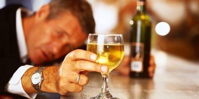 Om cu un pahar și o sticlă de alcool