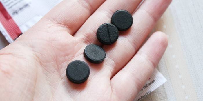 Tablete de carbon activat în palma mâinii