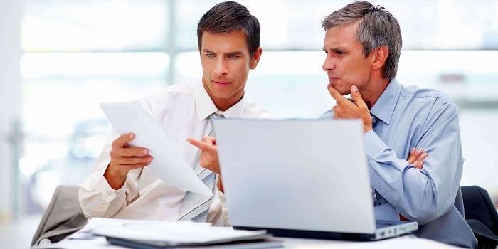 Homens no escritório trabalham com documentos