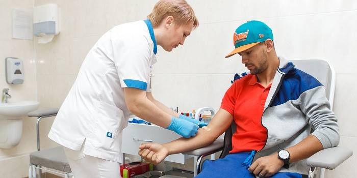 Uma enfermeira leva sangue de um paciente