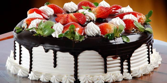 Torta csokoládéval borítva és bogyókkal díszítve a tetején