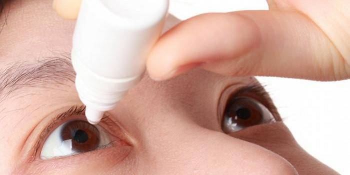 Tropfende Tropfen des Mädchens in den Augen