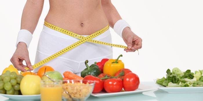 Legumes, frutas, um copo de suco e uma mulher