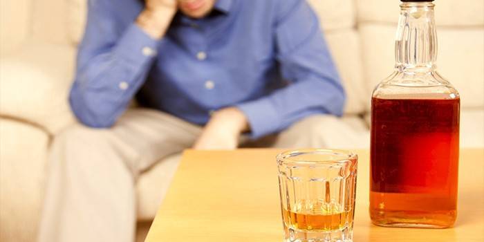 Muž a fľaša alkoholu
