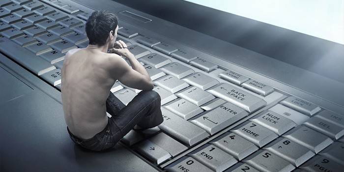 تمثال صغير لرجل يجلس على لوحة مفاتيح الكمبيوتر المحمول