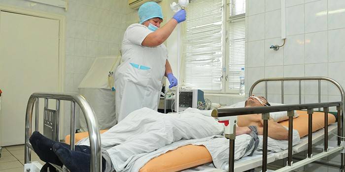 Ο ιατρός δίνει ένα σταγονόμετρο σε έναν ασθενή στον θάλαμο