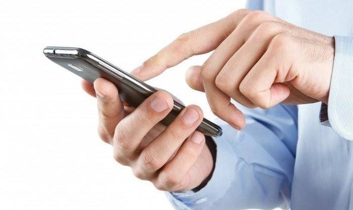 Un bărbat apelează un număr pe un smartphone