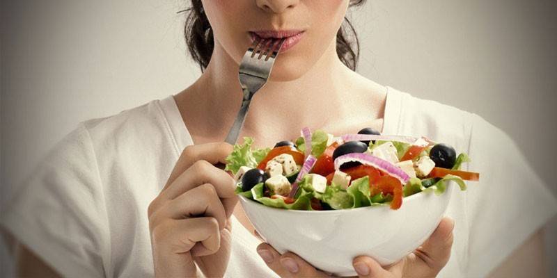 Fille mangeant de la salade