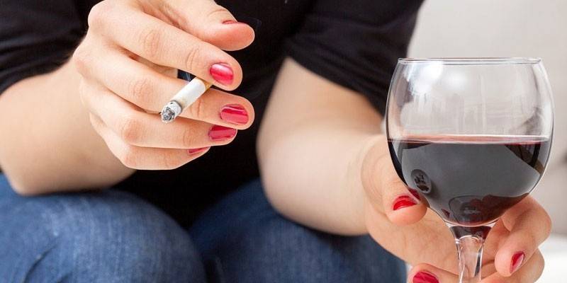 Fille fume et boit du vin.