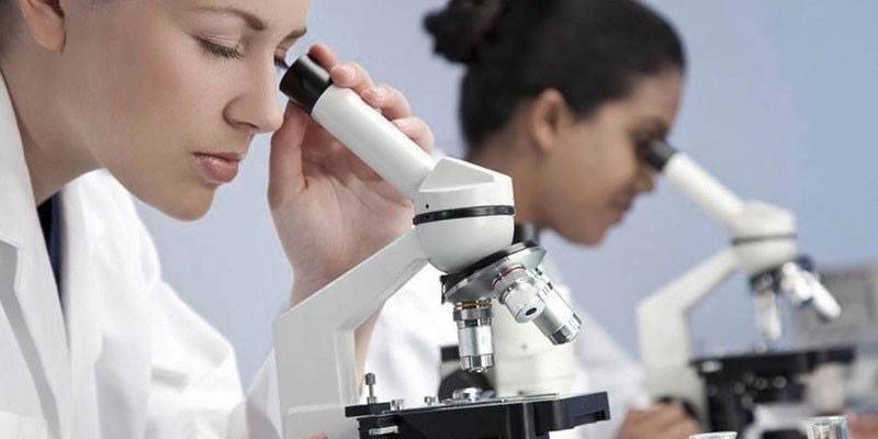 Assistenti di laboratorio al microscopio