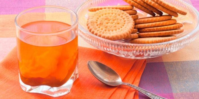 Copo com uma bebida e biscoitos