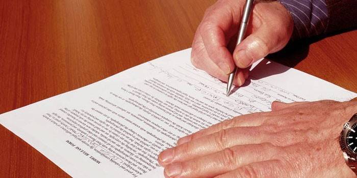 Người đàn ông ký một tài liệu
