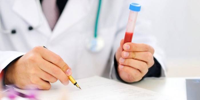 Il medico scrive e tiene una provetta