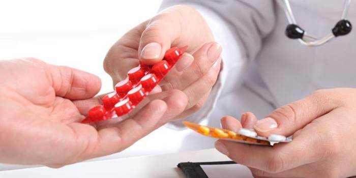 Medicul trece pastilele către pacient