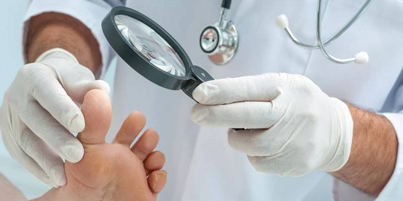 Un dermatologue examine la jambe d'un patient