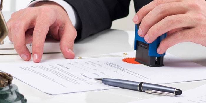 Homem coloca um carimbo em um documento