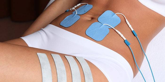 Tyttö vatsalihasten elektromyostimulaation istunnossa