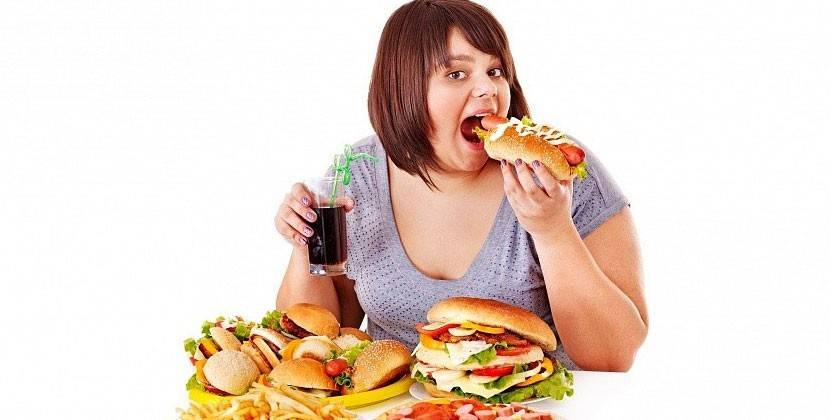 Femme en surpoids manger de la malbouffe