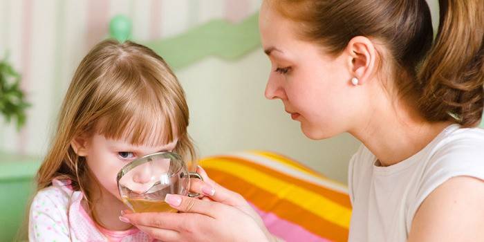 Mor giver babyen et kamilleafkog