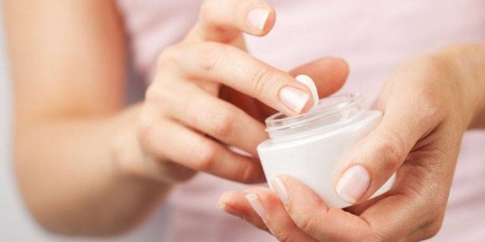 Pot de crème dans les mains