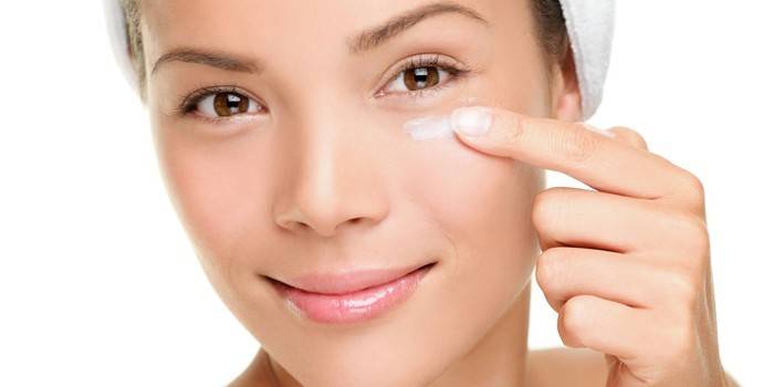 Fille met la crème sur la paupière